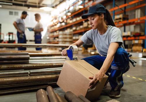 female-warehouse-worker-taping-cardboard-box-with-tape-dispenser-before-shipment_637285-3992